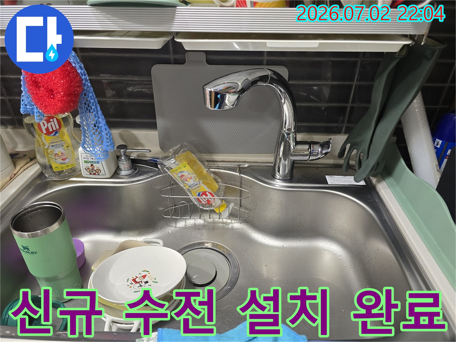 세척용 도구와 함께 배치된 깨끗한 상태의 주방 싱크대 및 새 수전