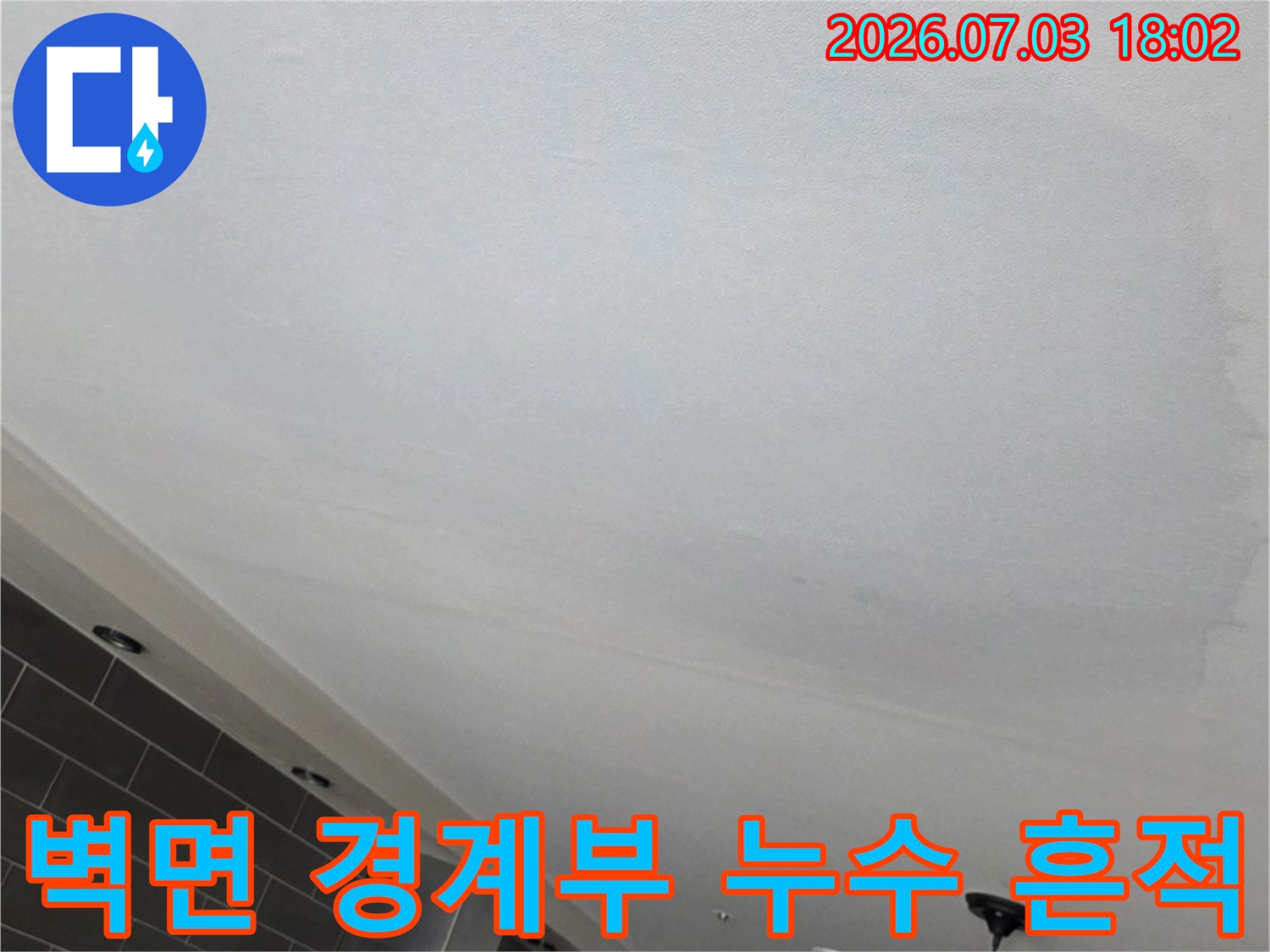 거실 천장 벽체 경계 부분까지 번진 누수의 변색된 둥근 자국