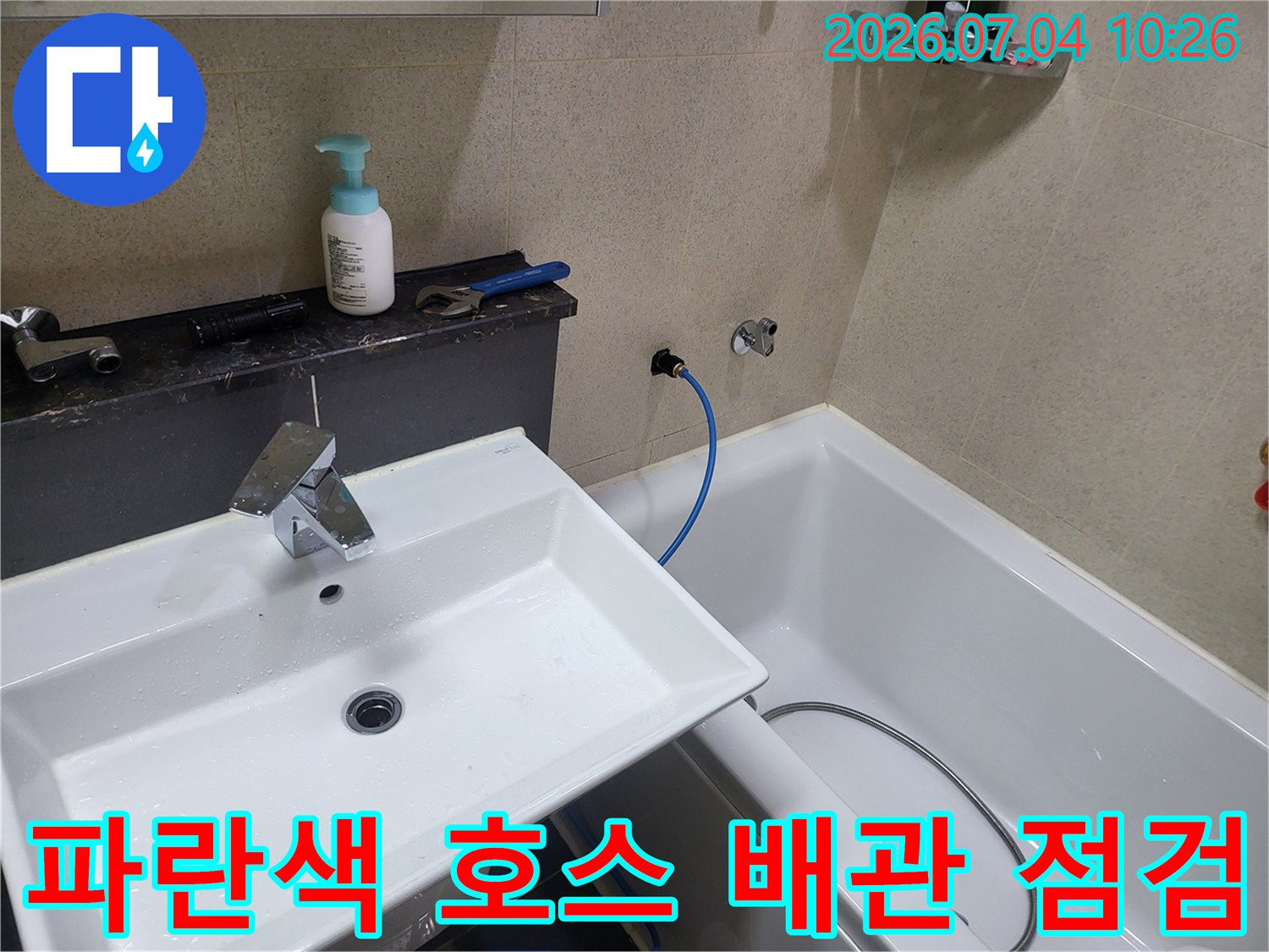 노출된 파란색 유연한 관과 고정 배관 사이의 연결부를 확인하는 과정