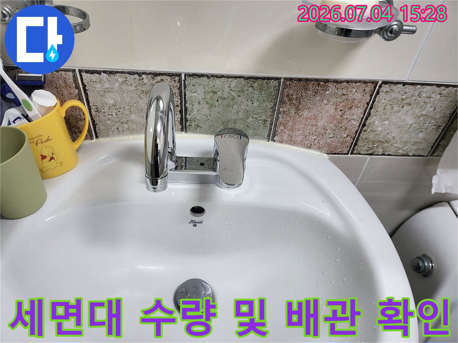 흰색 세면대에 설치된 수전과 주변 타일 마감재의 상태 확인