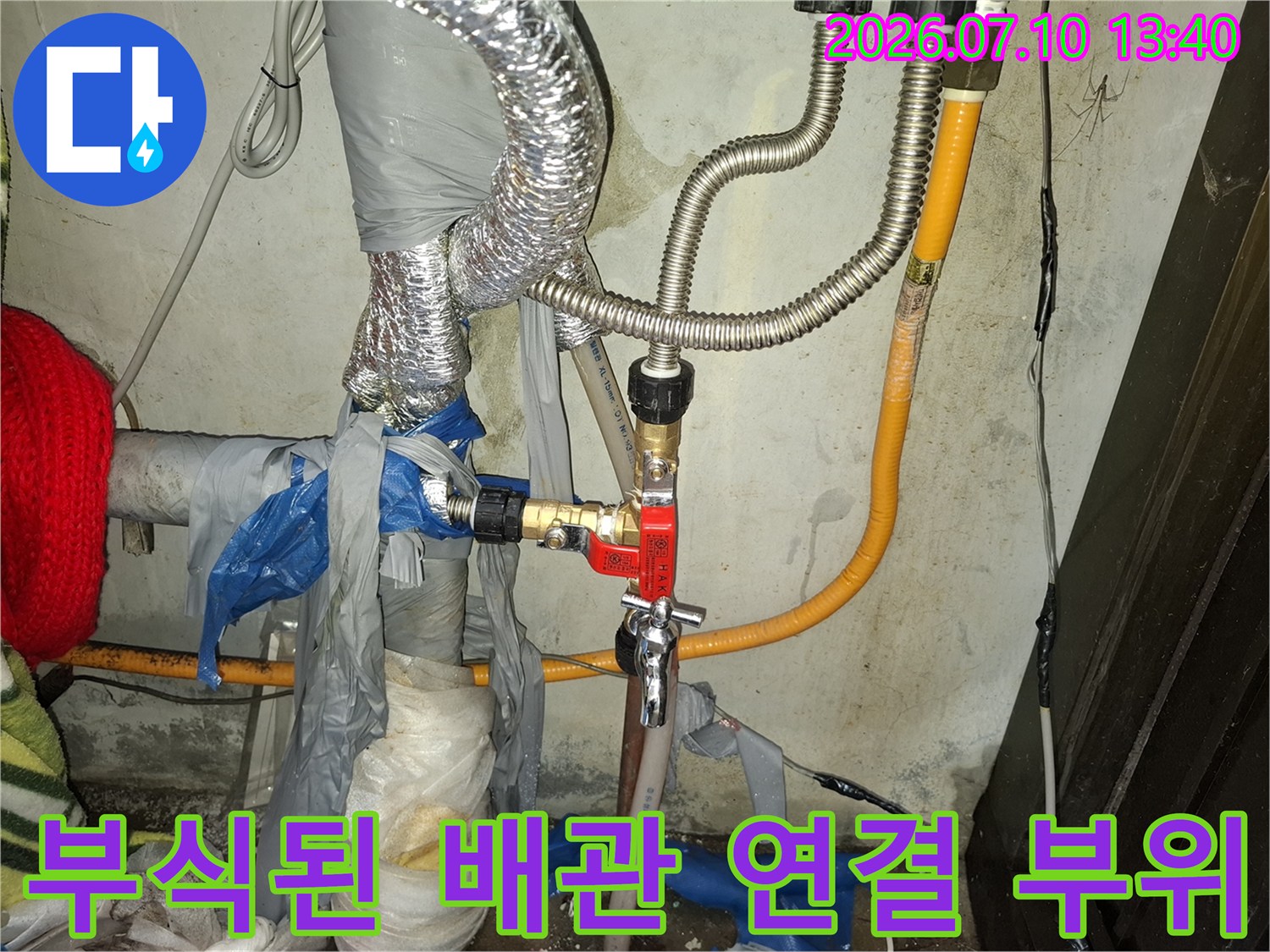 은색 보온재로 감싸진 배관과 노출된 금속 연결부의 누수 확인 작업
