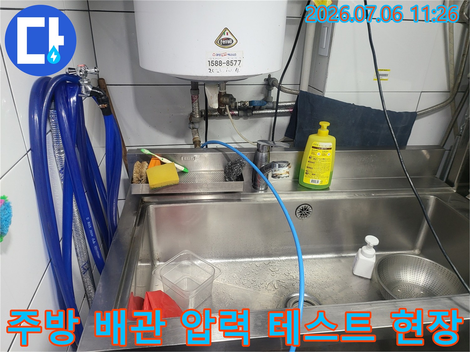 파란색 점검용 호스를 싱크대 아래 배관에 연결하여 누수를 정밀 진단하는 모습