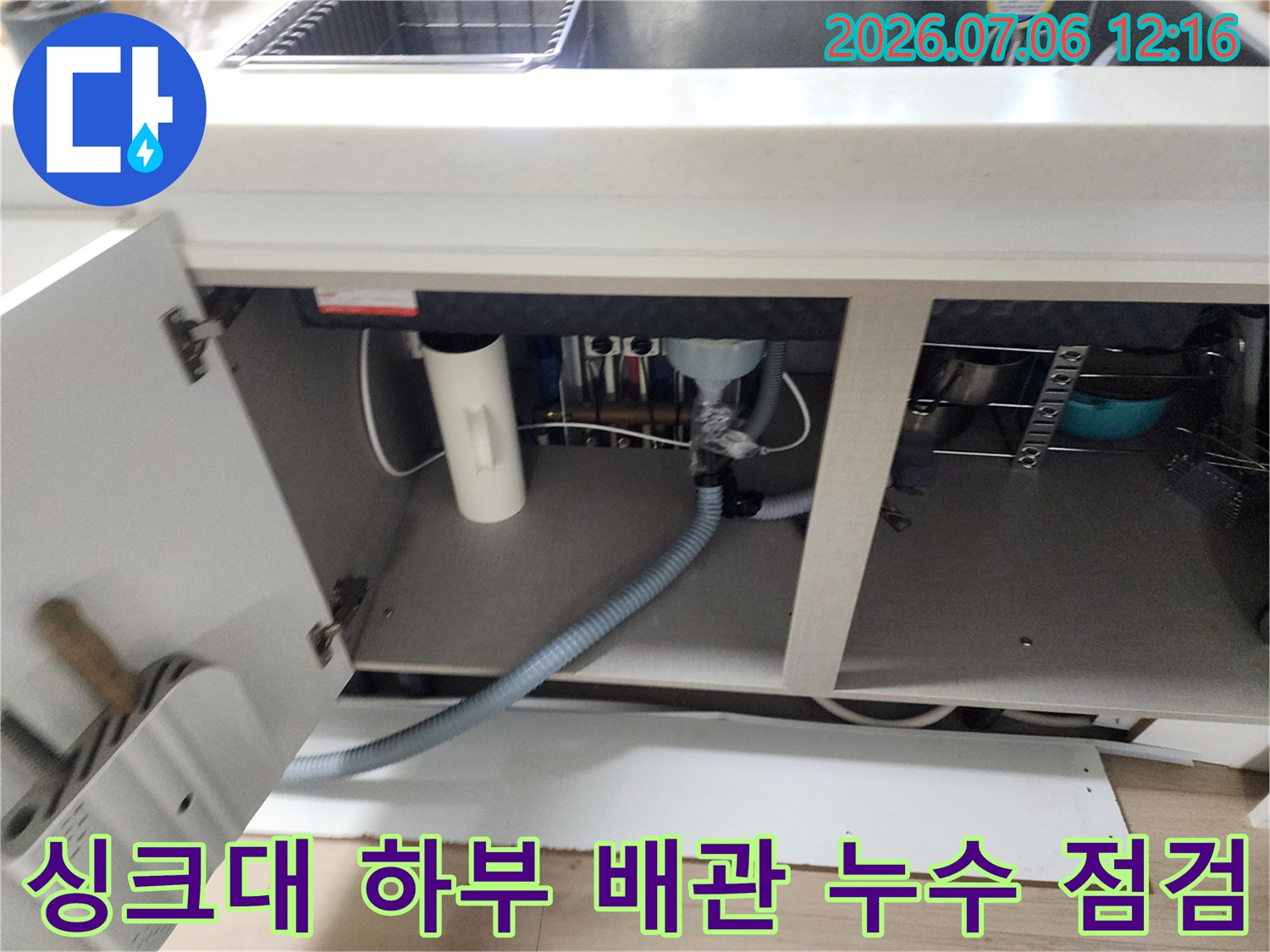 싱크대 밑에 위치한 회색 배출용 호스의 연결 상태 확인