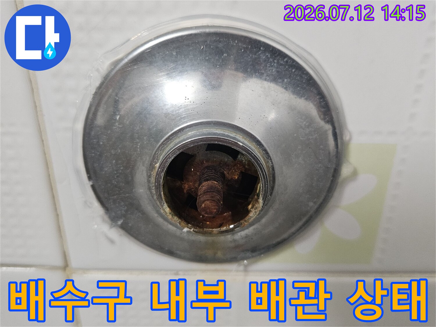 노출된 배수구 주변의 노후된 배관과 오염 부위