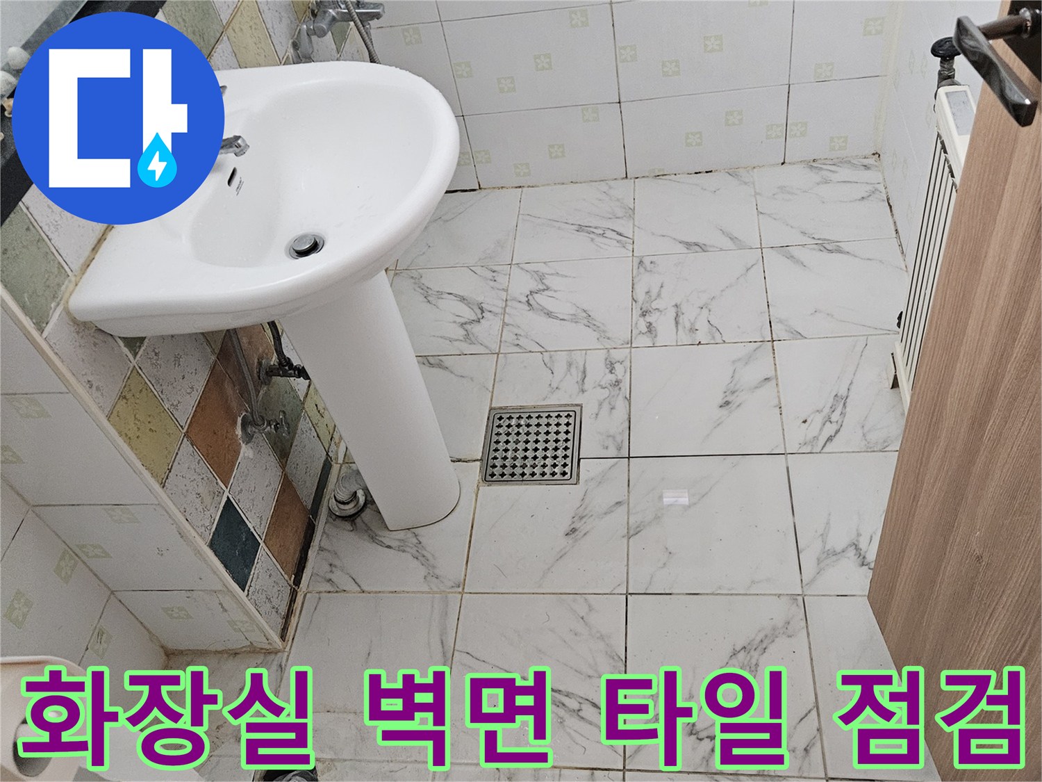 흰색 세면대 아래쪽의 타일 및 배수구 상세 사진