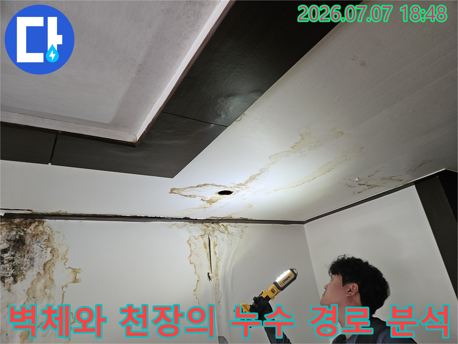 천장과 벽면 경계부의 물자국을 정밀 장비로 촬영하고 있는 장면