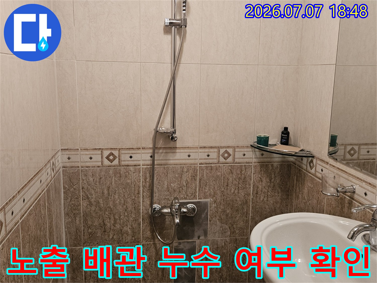 화장실 세면대 근처 노출된 배관 시스템을 촬영한 진단 기록용 사진