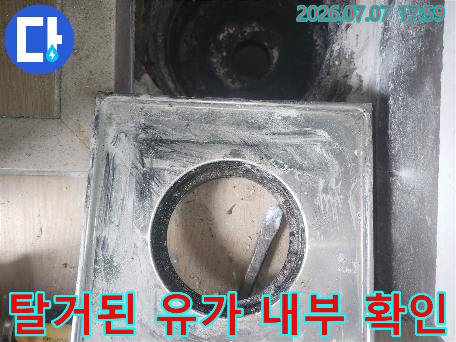 세탁실 하수구 유가를 탈거하여 배수관 주변 상태를 점검하는 모습