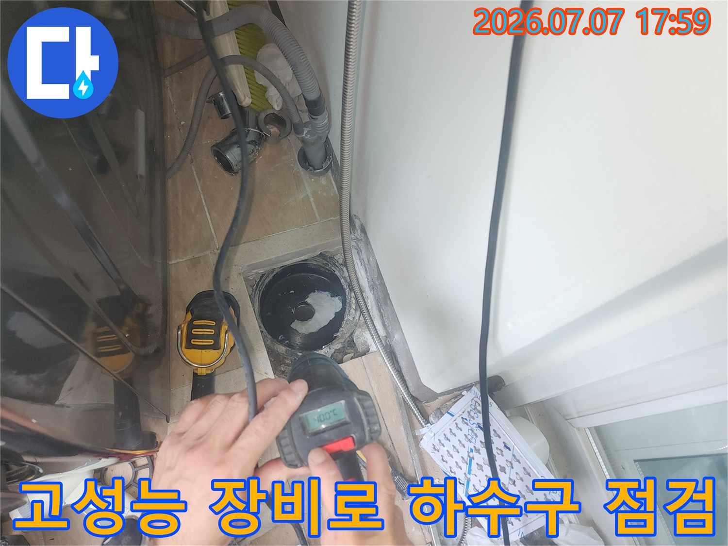 전문가용 측정기를 들고 세탁실 배수관 주변을 정밀하게 진찰하는 장면