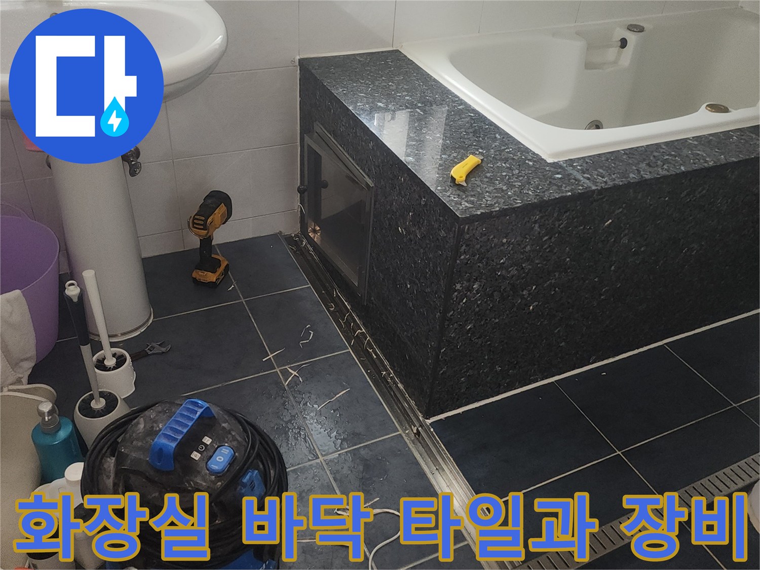 욕실 바닥 타일 주변에 배치된 청소 장비와 작업 도구