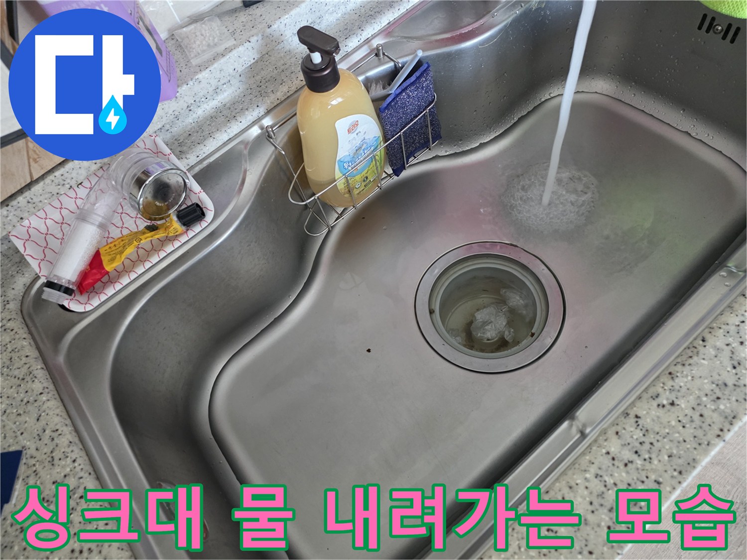 스테인리스 싱크대에 물이 쏟아지며 배수되는 장면