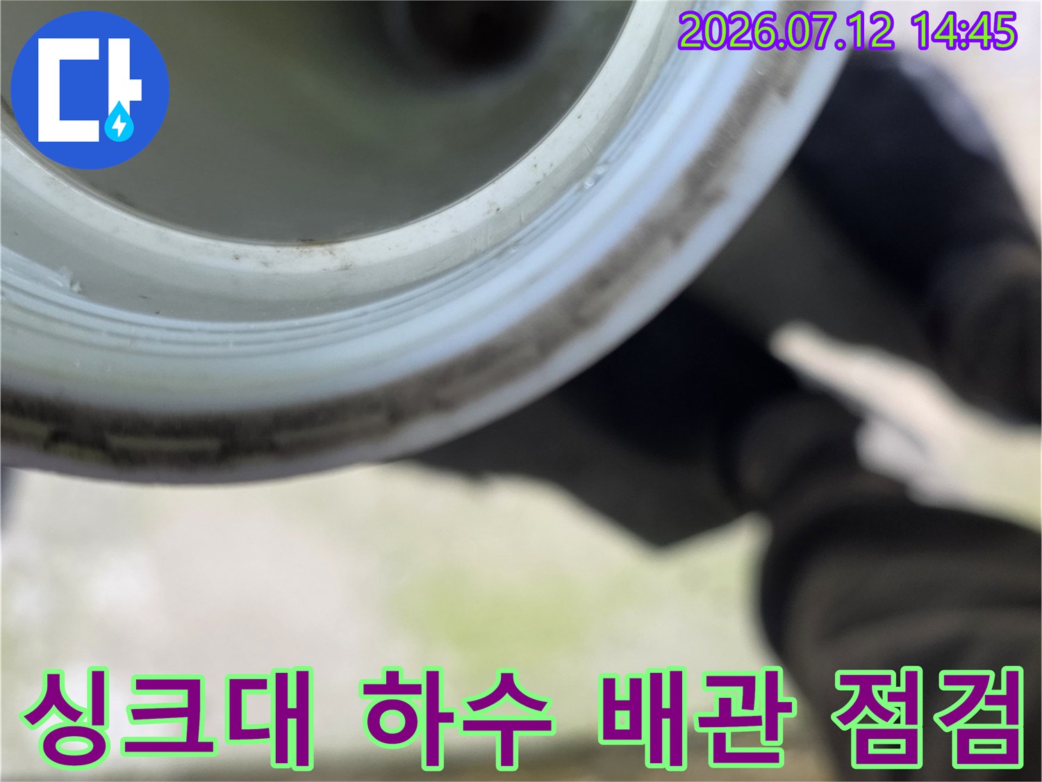 싱크대 아래쪽 노출된 하수관을 근접 촬영한 모습