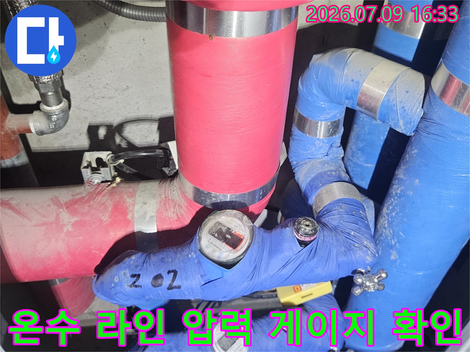 다양한 색상의 보온재로 마감된 배관과 설치된 압력계의 모습