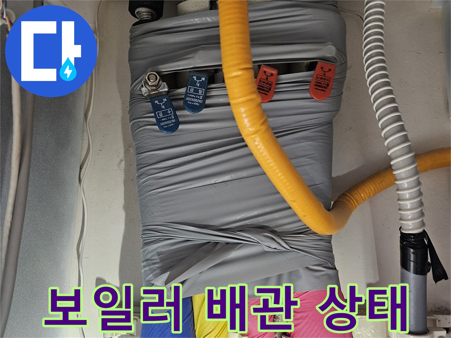 보온재로 감싸진-다양한 종류의 배관이 모여 있는 모습입니다.