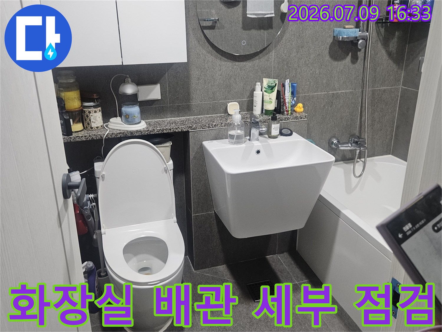 화장실 변기와 수전 주변의 배관 연결 부위를 정밀하게 점검하는 모습