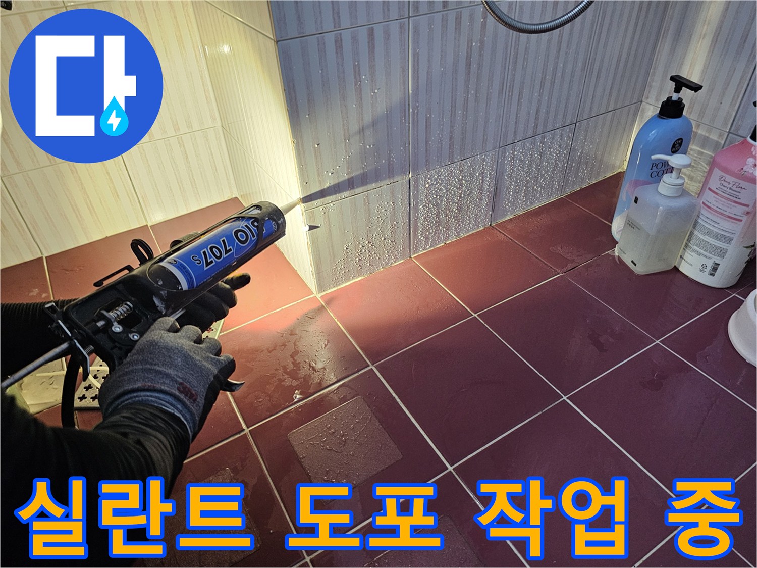 전문가가 실란트 건을 사용하여 타일 경계면에 방수제를 주입하는 장면