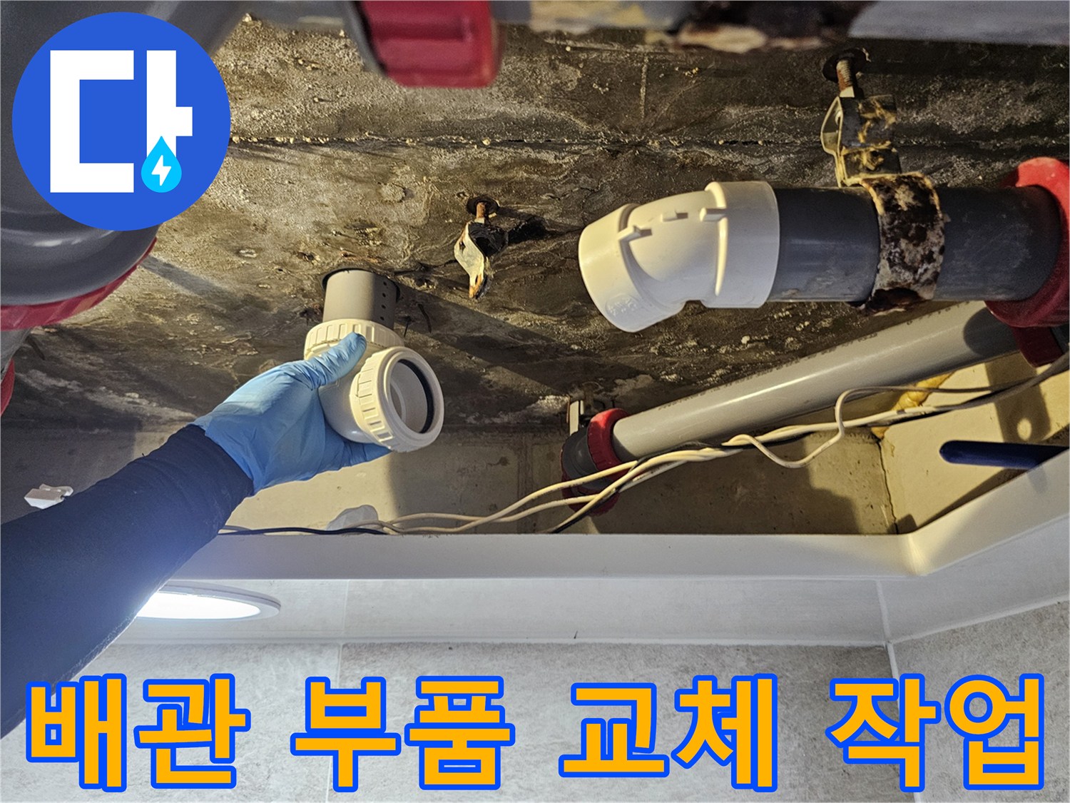 파란 장갑을 낀 엔지니어가 배관 연결 부속을 정밀하게 맞추고 있습니다.