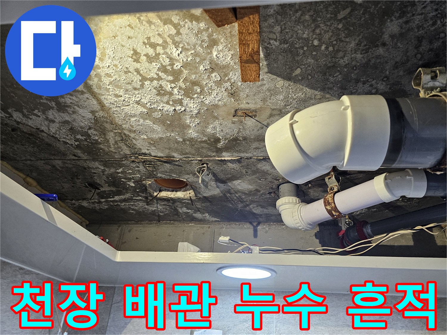 하얀 배관 주변에 넓게 퍼진 천장 내부의 물자국과 얼룩