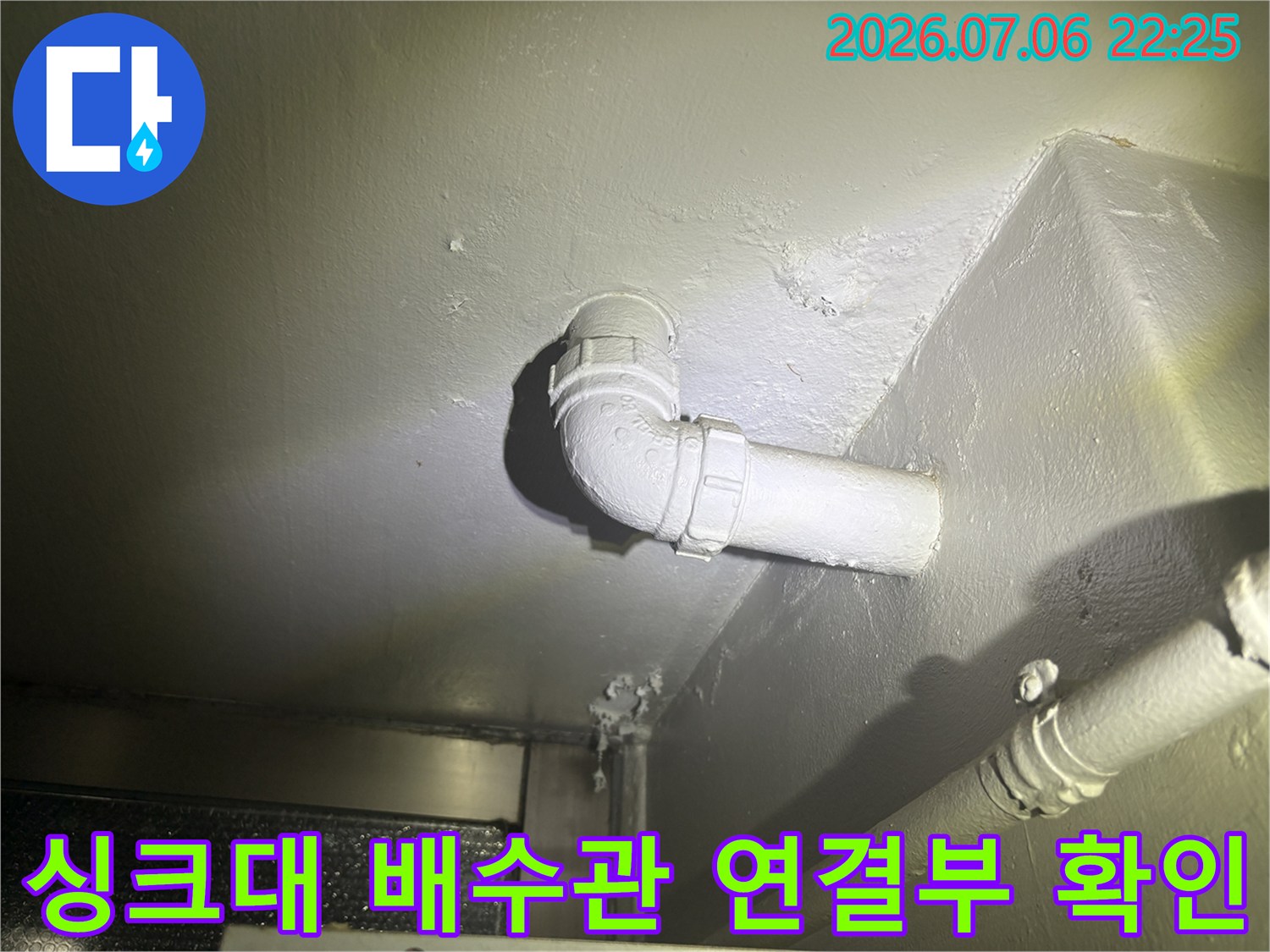 천장에 고정된 싱크대 배수용 파이프와 엘보우 연결 부위 상세 촬영
