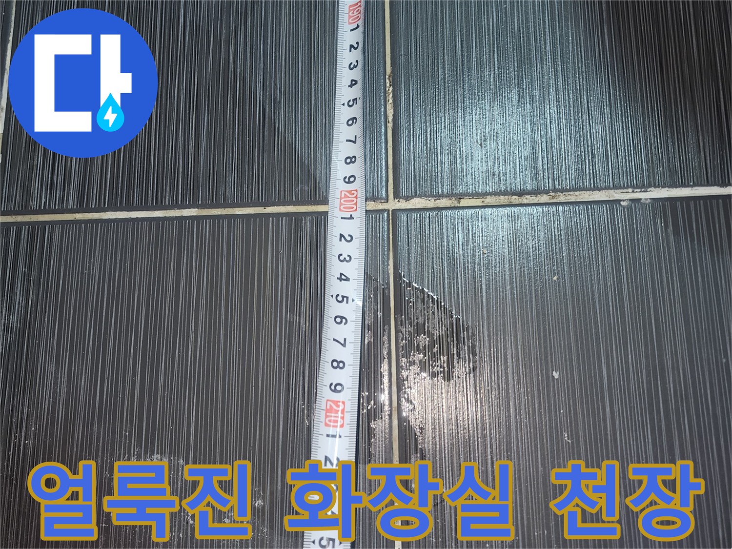 물기가 스며들어-얼룩이 생긴 화장실 천장의 타일 표면 사진입니다.