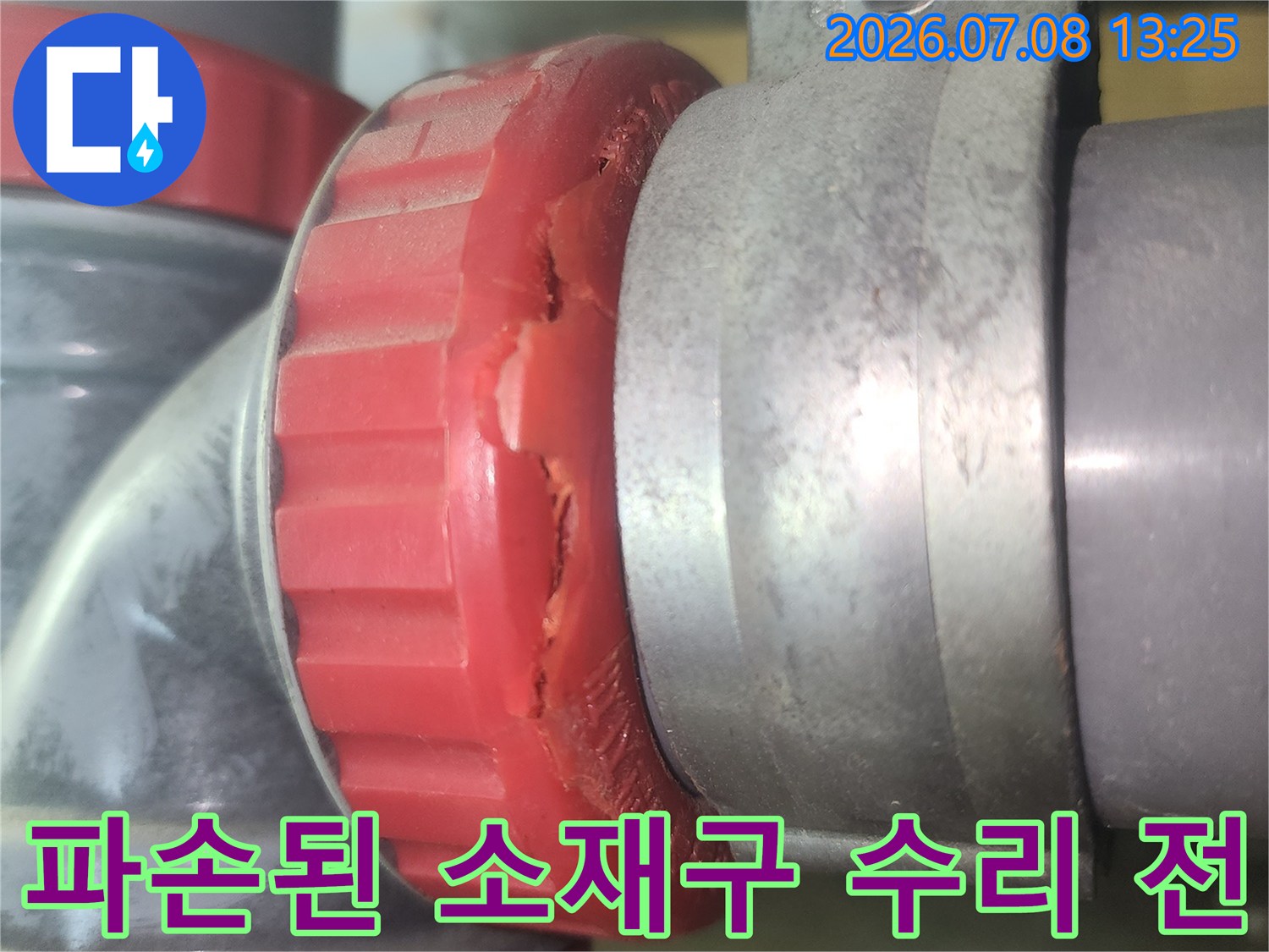 붉은색 덮개형 배관 부속이 파손되어 누수가 발생하는 현장 사진