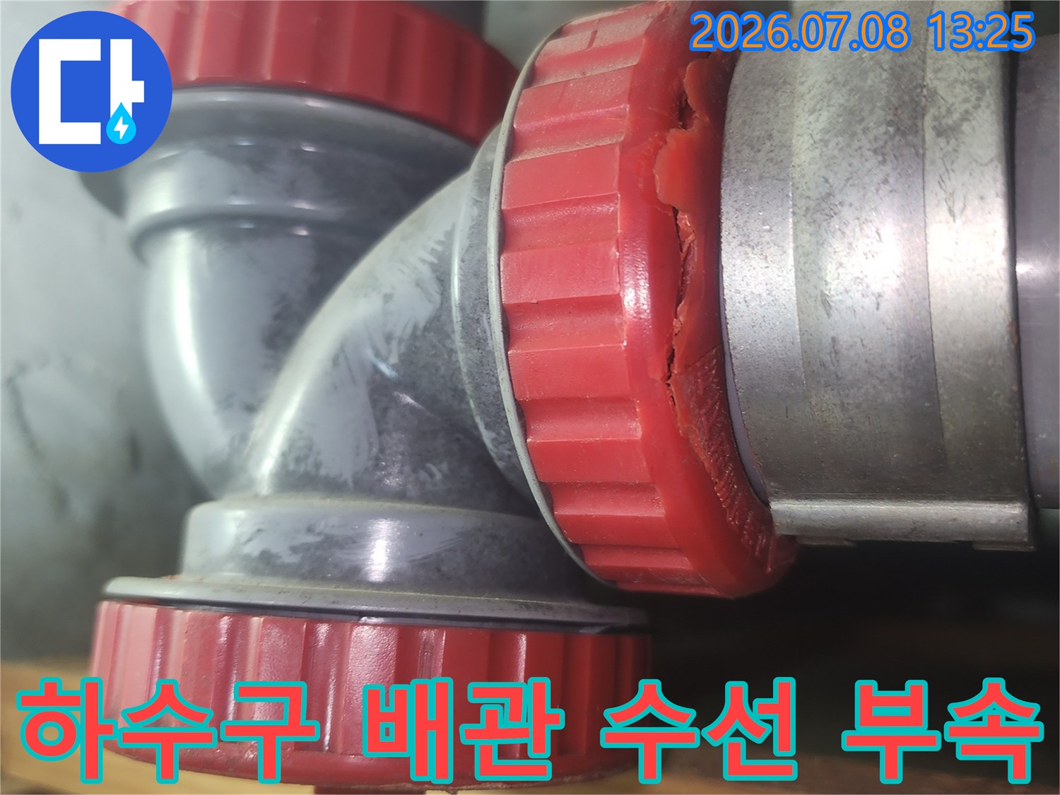빨간색 캡이 씌워진 하수 배관 연결부위 수리 모습