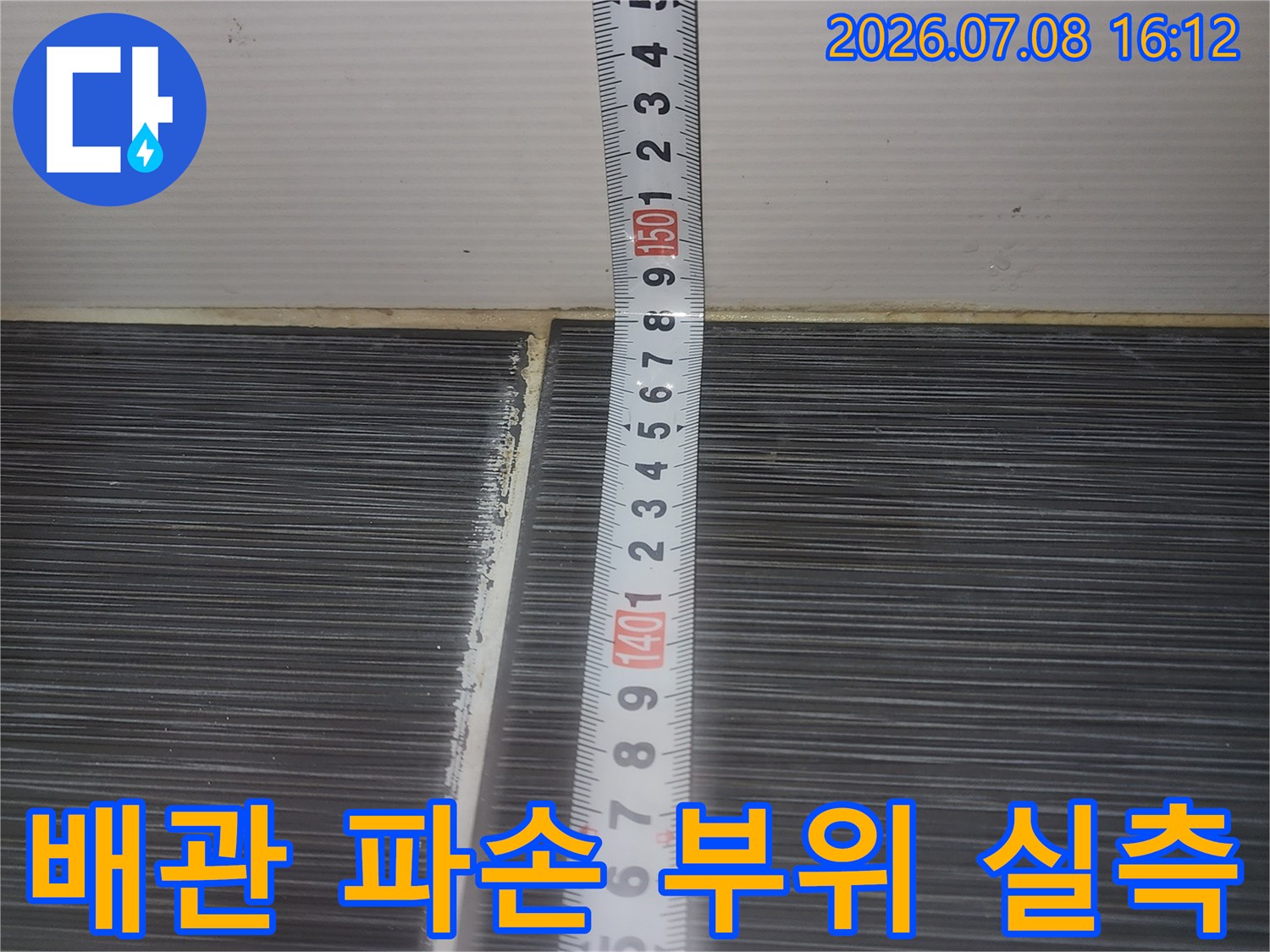 줄자로 하수 배관의 길이를 측정하며 수선 계획을 세우는 모습