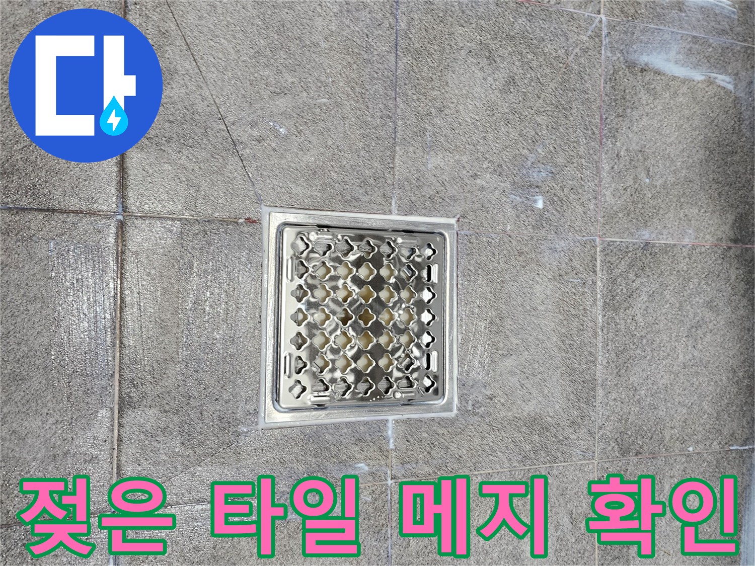 화장실 배수구 주변의 젖어 있는 타일 상태 사진