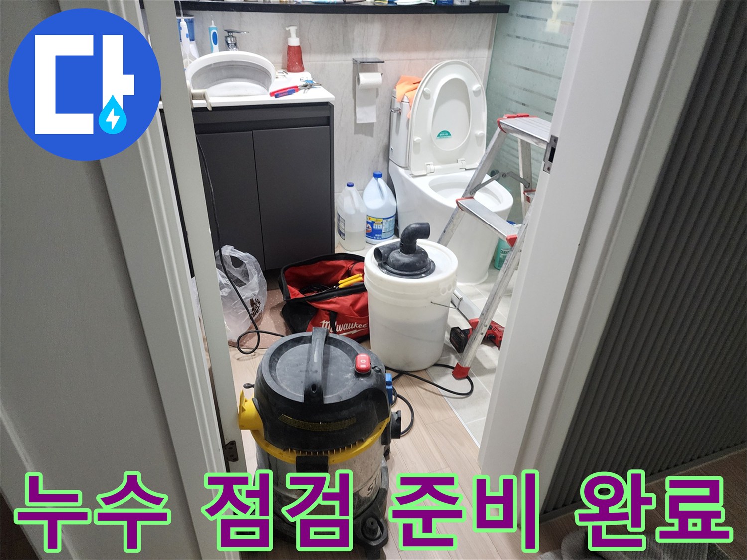 화장실 바닥에 세팅된 산업용 청소기와 사다리