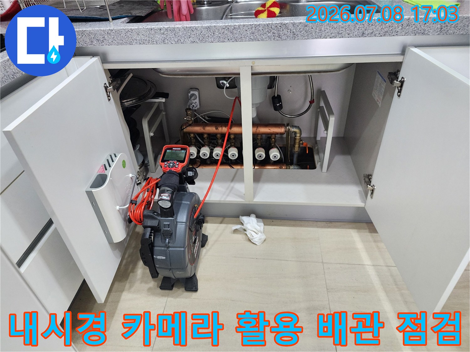 싱크대 내부의 좁은 공간에서 내시경 장비를 사용하여 배관 결함을 정밀 진단하는 모습