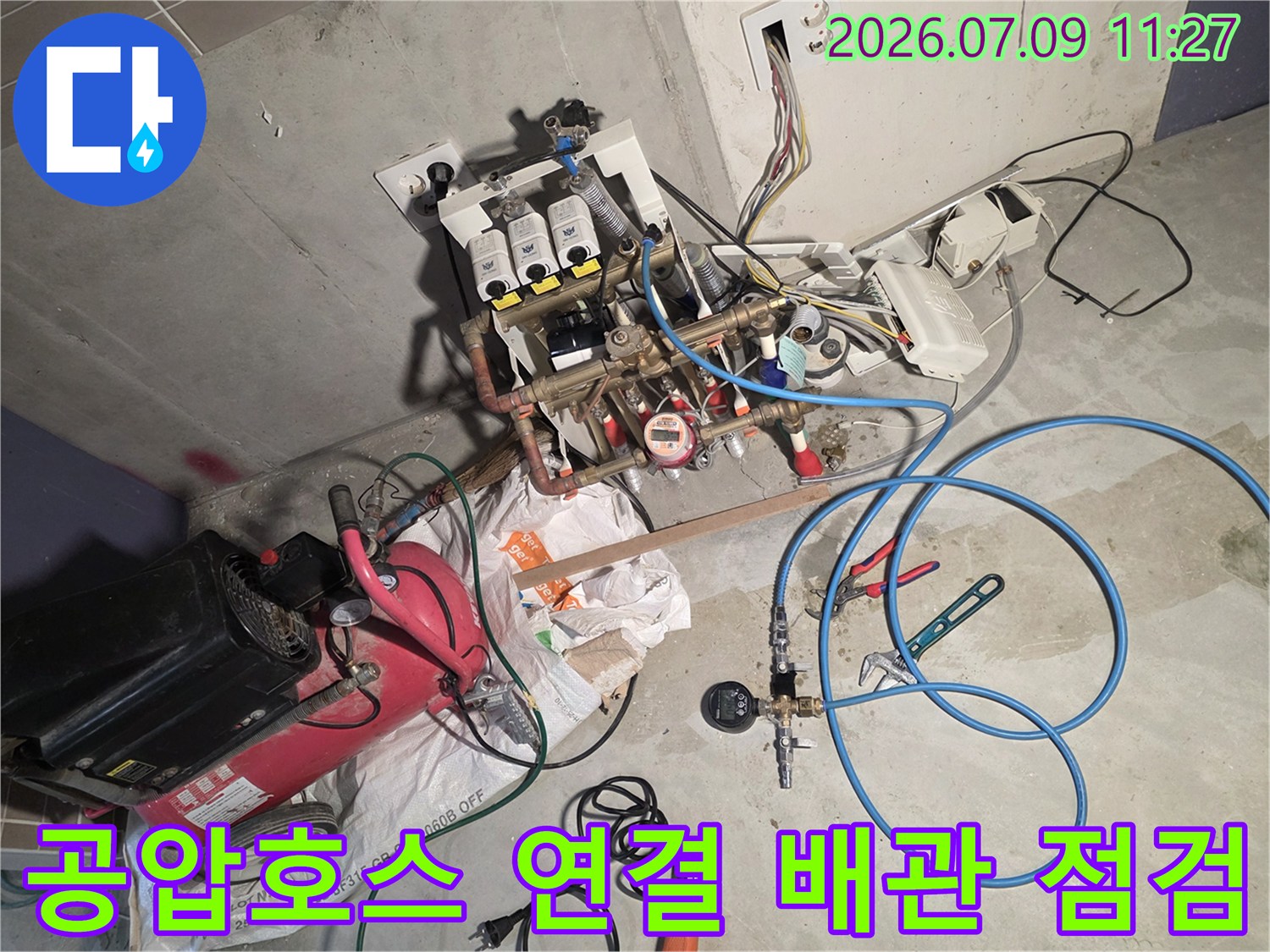 파란색 공압 호스를 분배기 배관에 연결하여 기밀 시험을 진행하는 모습