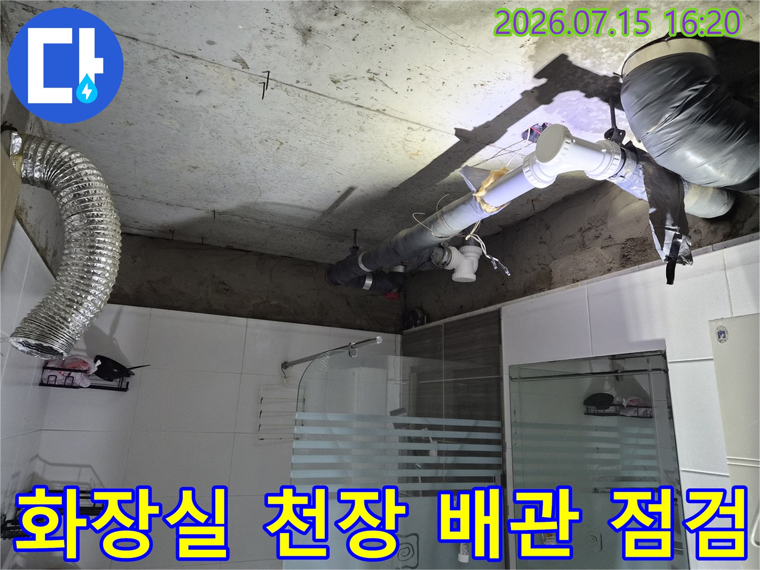 노출된 화장실 천장 내부의 배관 시설과 환풍기 덕트 구조