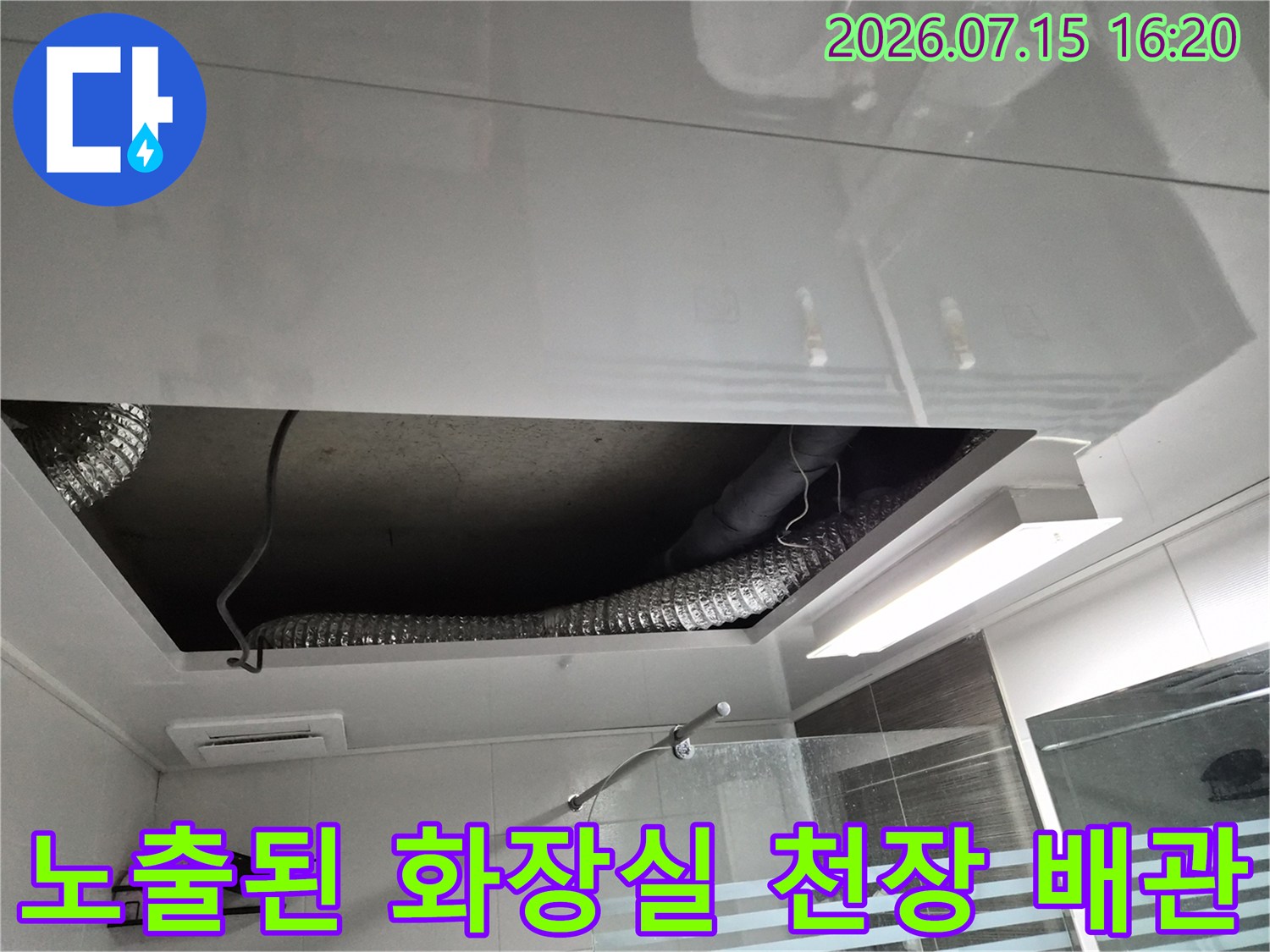화장실 천장 안쪽의 복잡한 배관과 환기 덕트 설비를 촬영한 사진