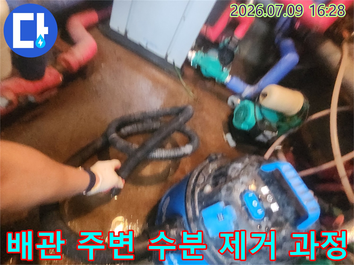 석션기를 사용하여 배관 연결부 주변의 물을 흡입하는 모습