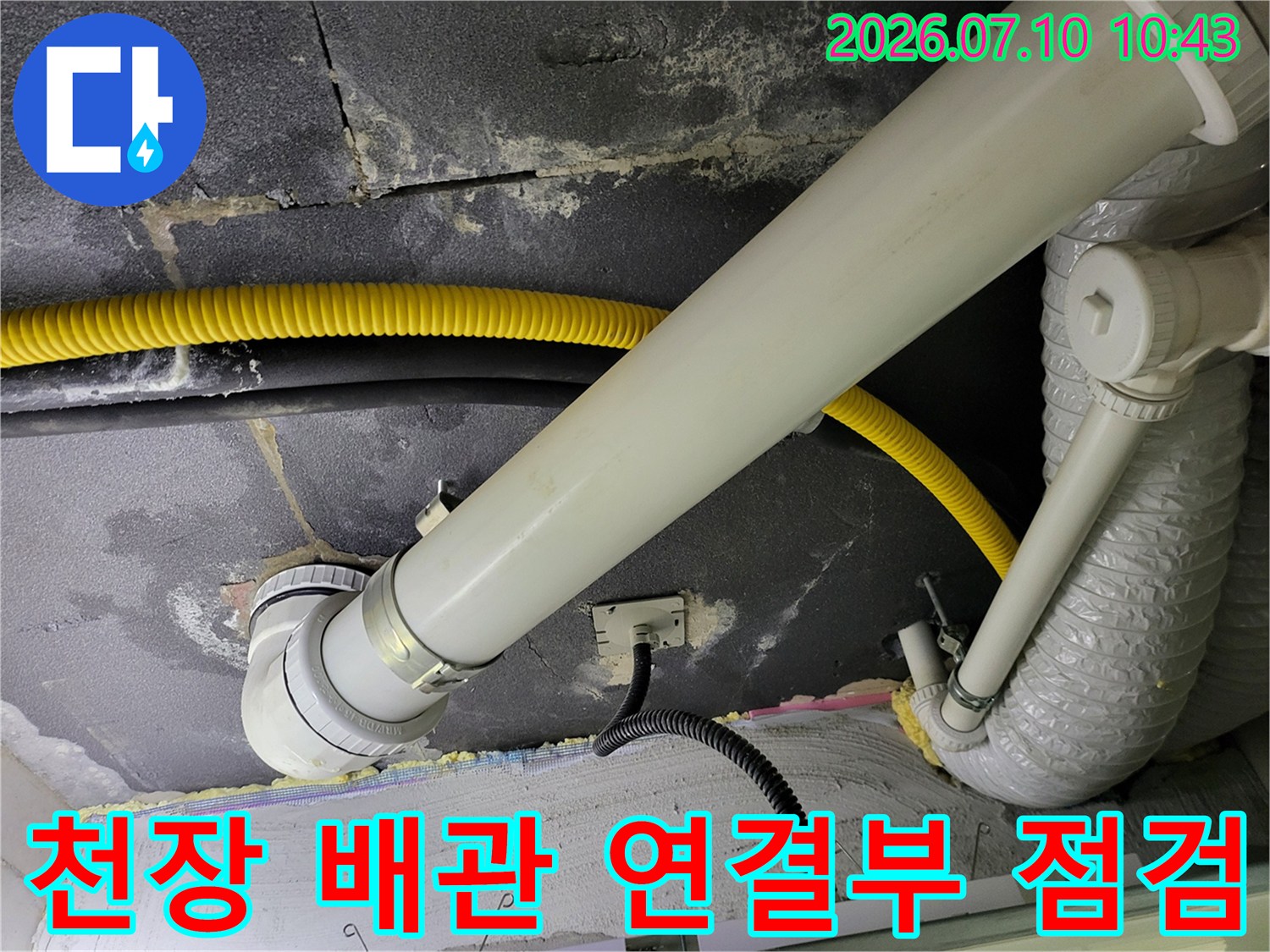 배관 연결 부위와 노란색 보호재가 있는 화장실 천장 내부 모습