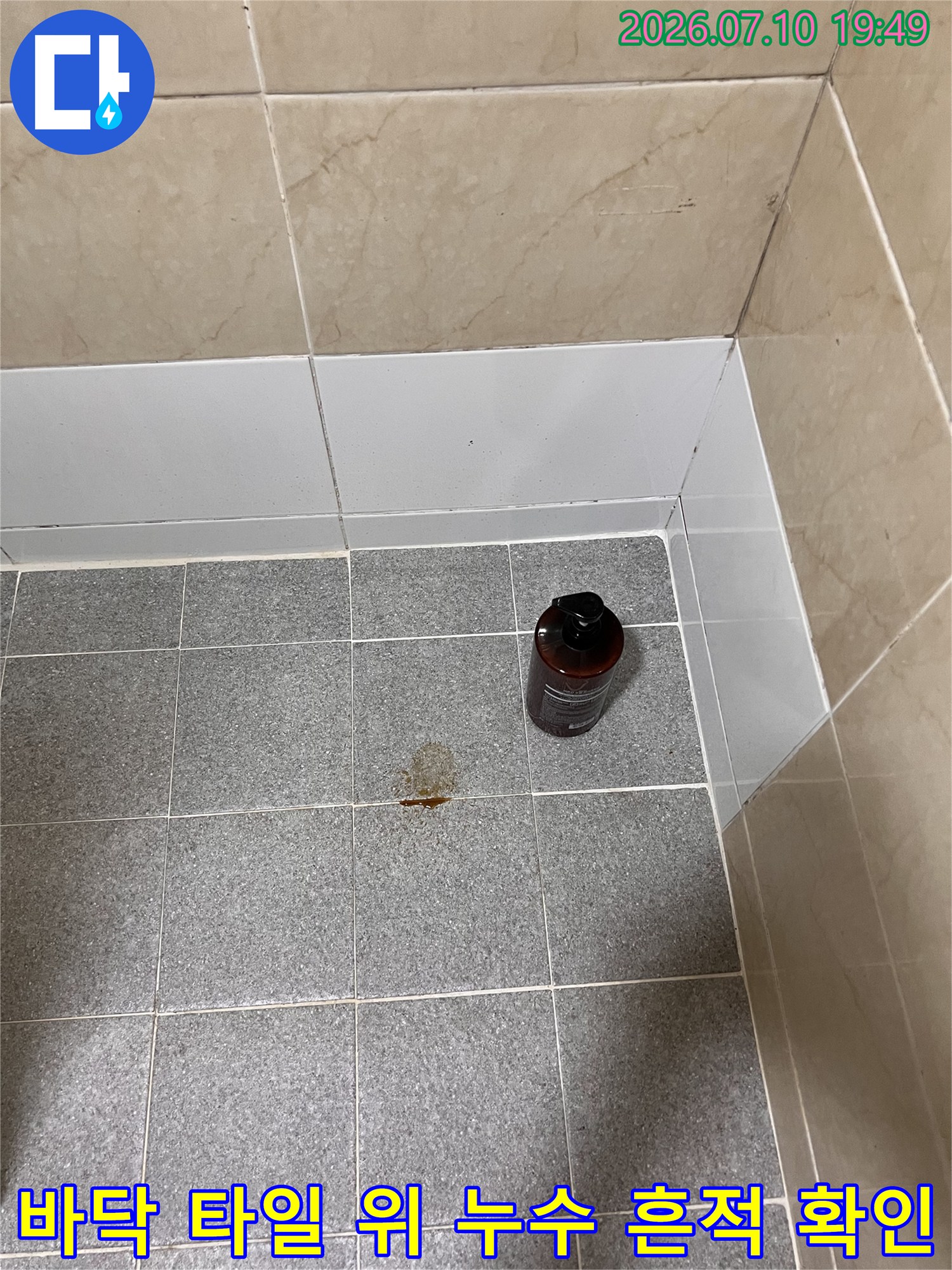 타일 바닥에 나타난 갈색 얼룩과 누수 탐지용 장비 배치 모습