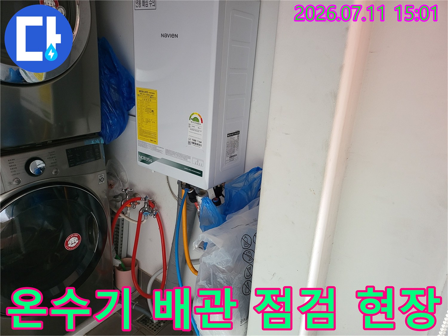 세탁기와 온수기 옆에 위치한 수도 배관 시스템을 점검하는 모습