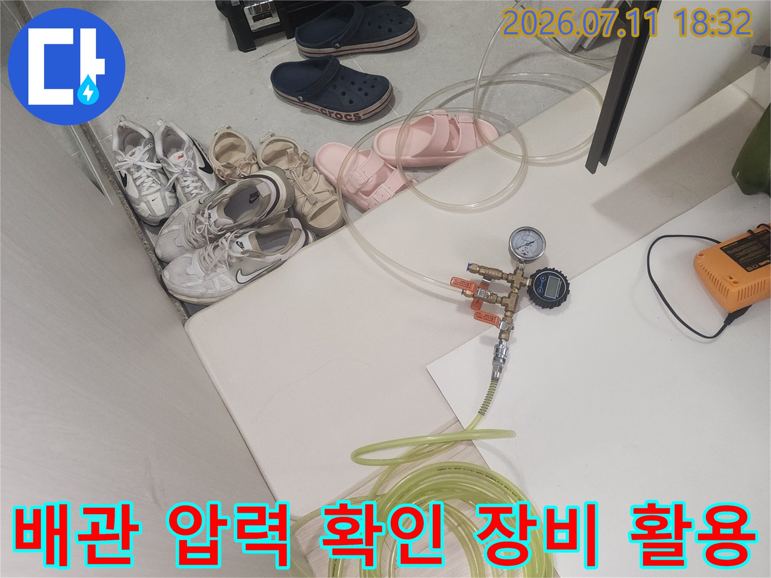 공압 검사기와 호스를 연결하여 직수 배관의 기밀 상태를 모니터링하는 모습