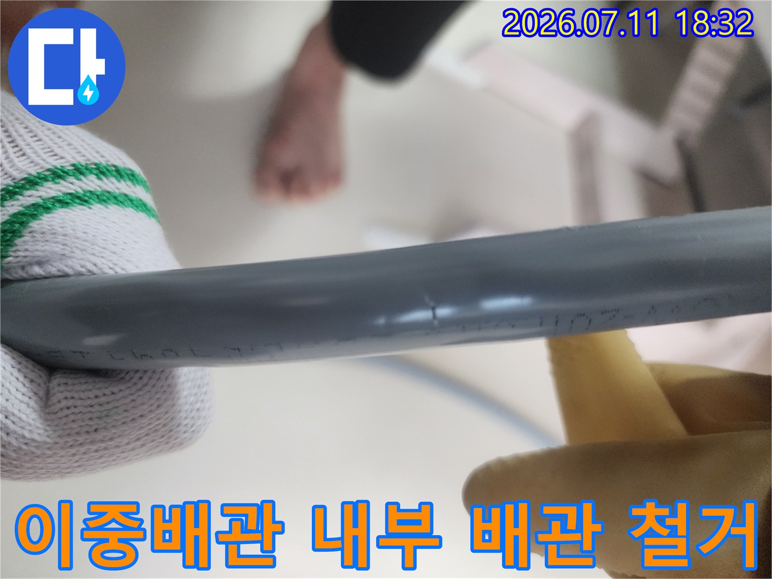 장갑 낀 손으로 회색 직수 배관을 파지하는 모습