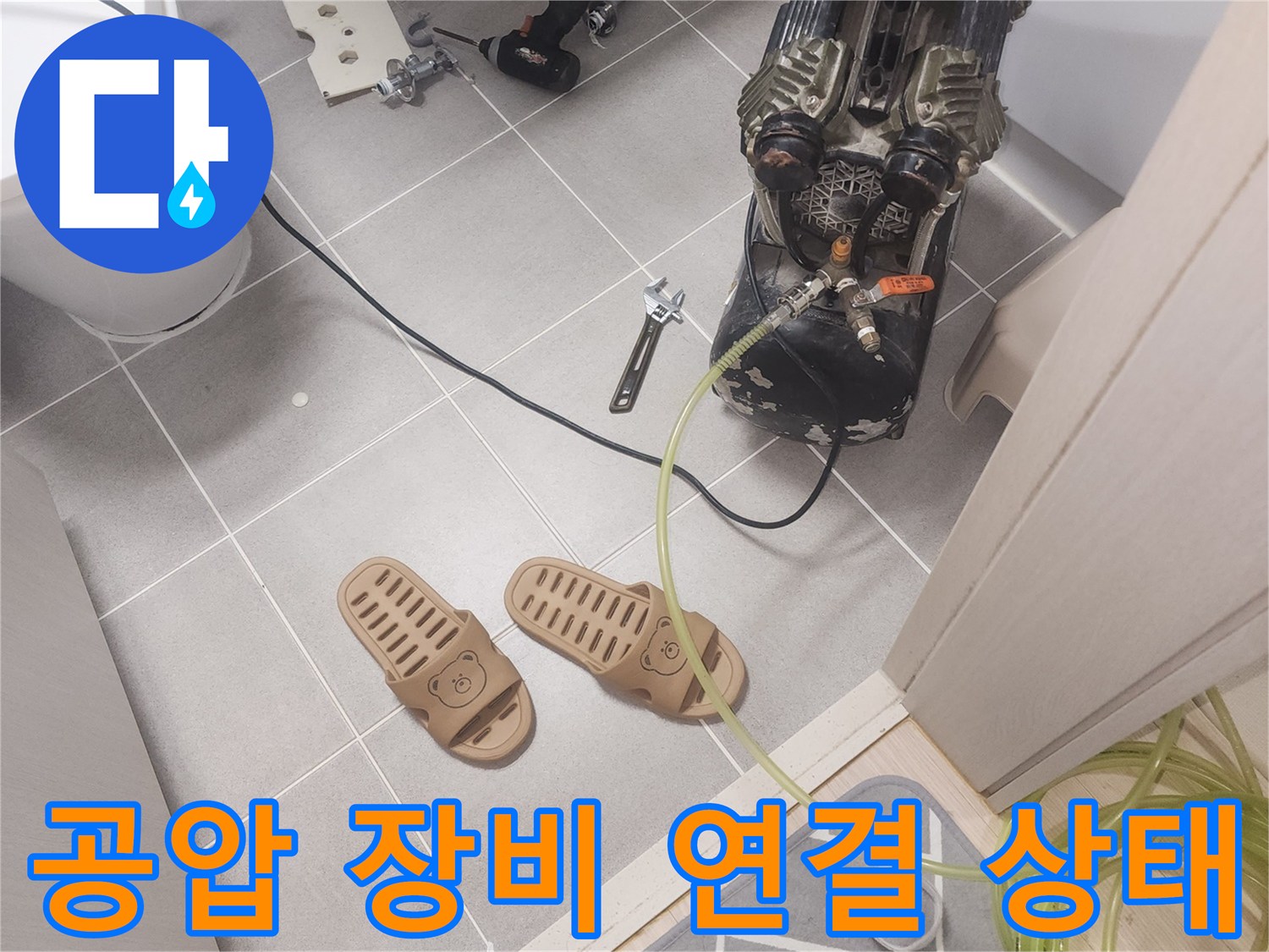 타일 바닥에 배치된 공압 검사용 호스와 압력계 연결 부위