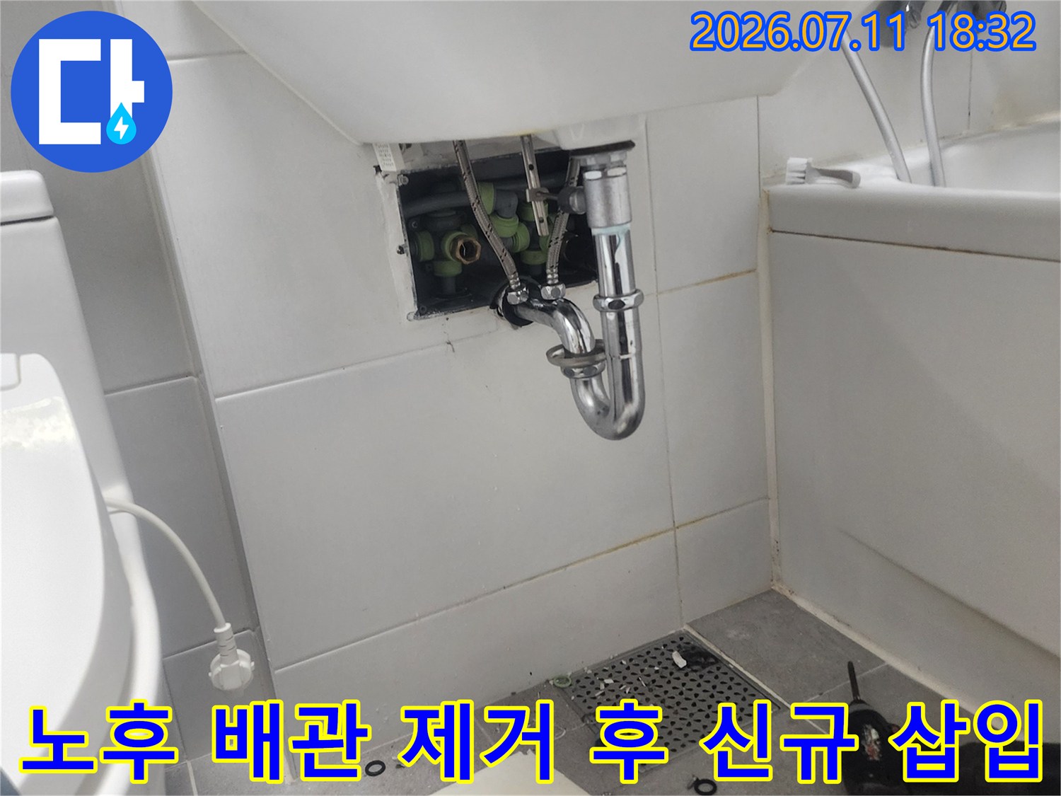 화장실 타일 구간에서 새롭게 교체된 금속 직수 배관과 연결용 부품들