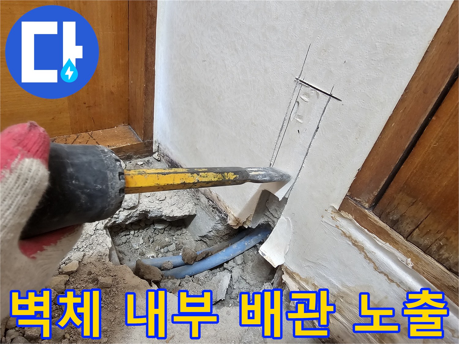 공구를 사용하여 벽면을 깎아내고 배관을 드러낸 공사 현장