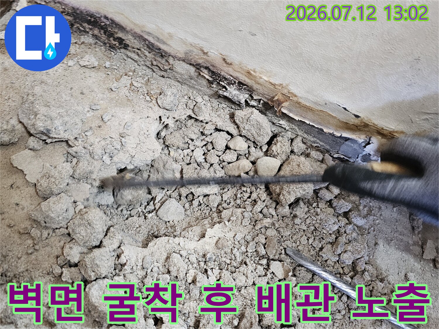 벽면을 파쇄하여 노출된 직수 배관과 주변의 토사 상태