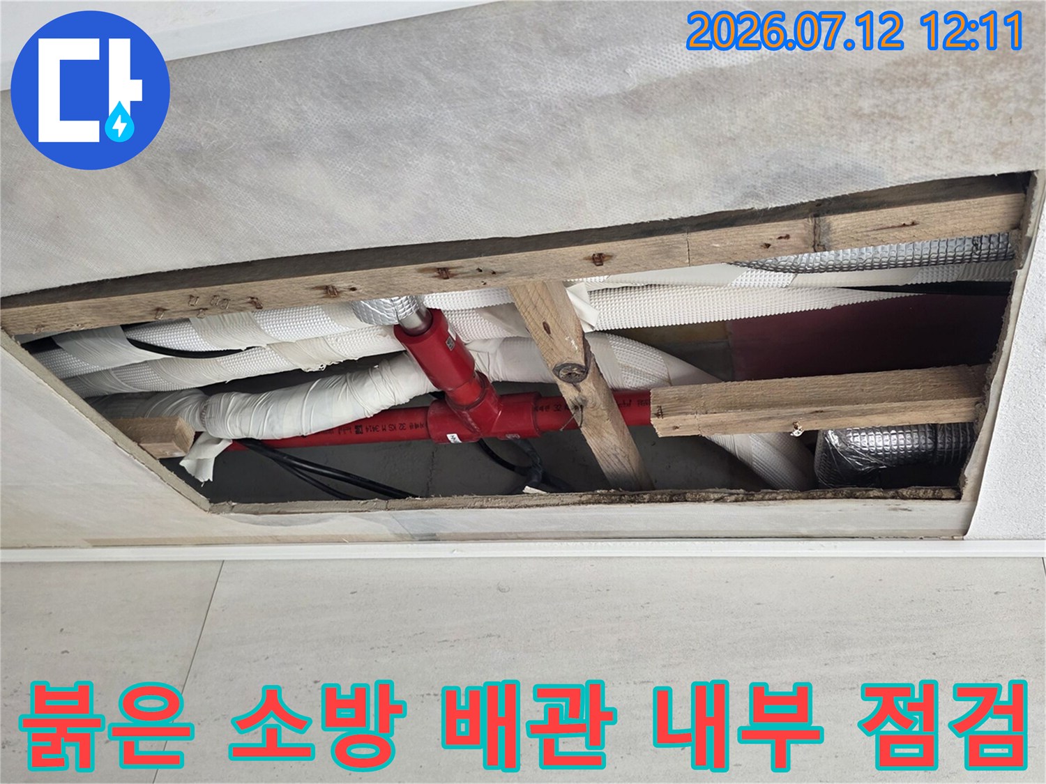 복잡한 천장 속 붉은색과 흰색의 다양한 설비 배관을 점검하는 현장 사진