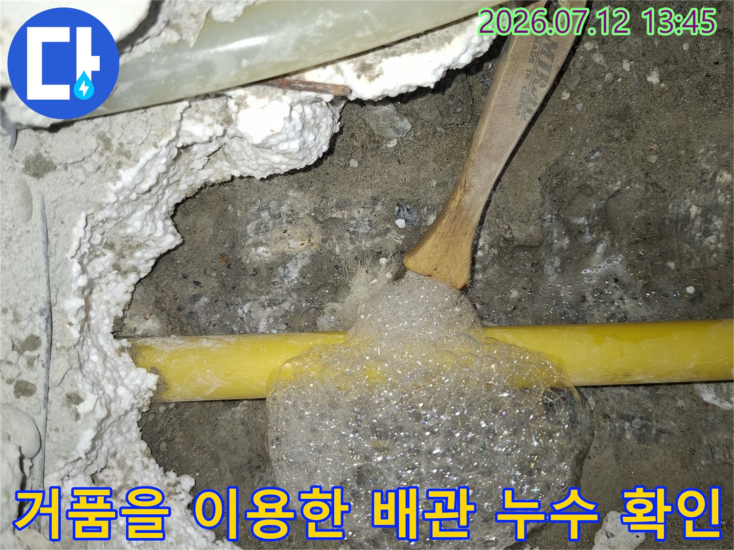 노란색 직수배관에 거품을 묻혀 누수 지점을 찾는 장면
