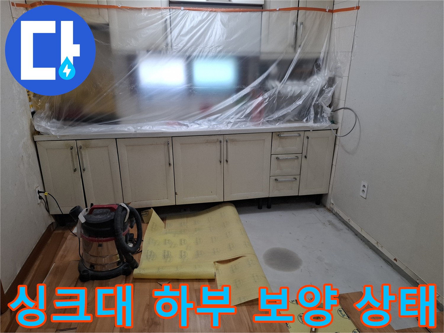 싱크대 아래쪽 - 비닐과 보호 시트로 덮인 작업 현장