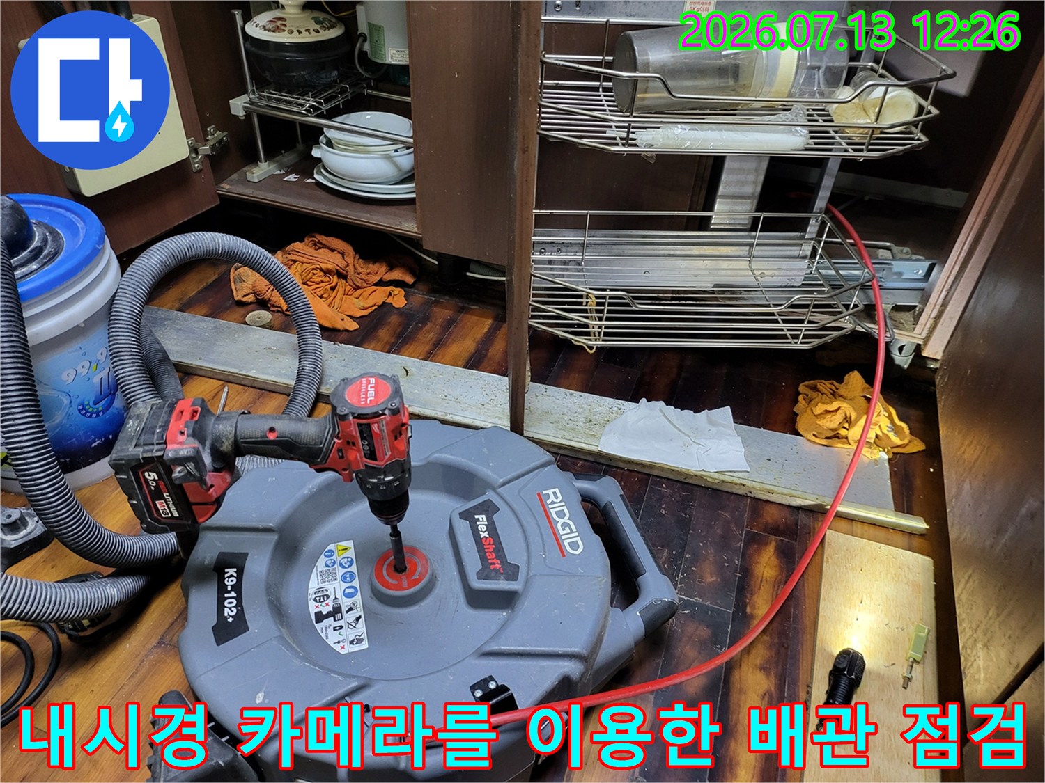 석션기와 내시경이 연결된 싱크대 하부 배관 진단 장면