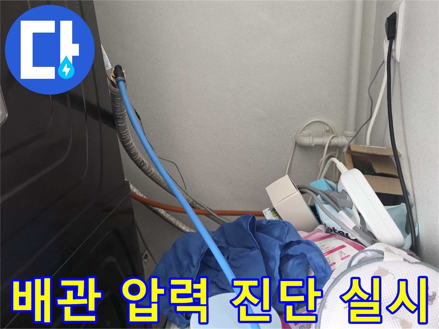 파란색 호스가 연결된-세탁기 근처 수도 배관의 모습