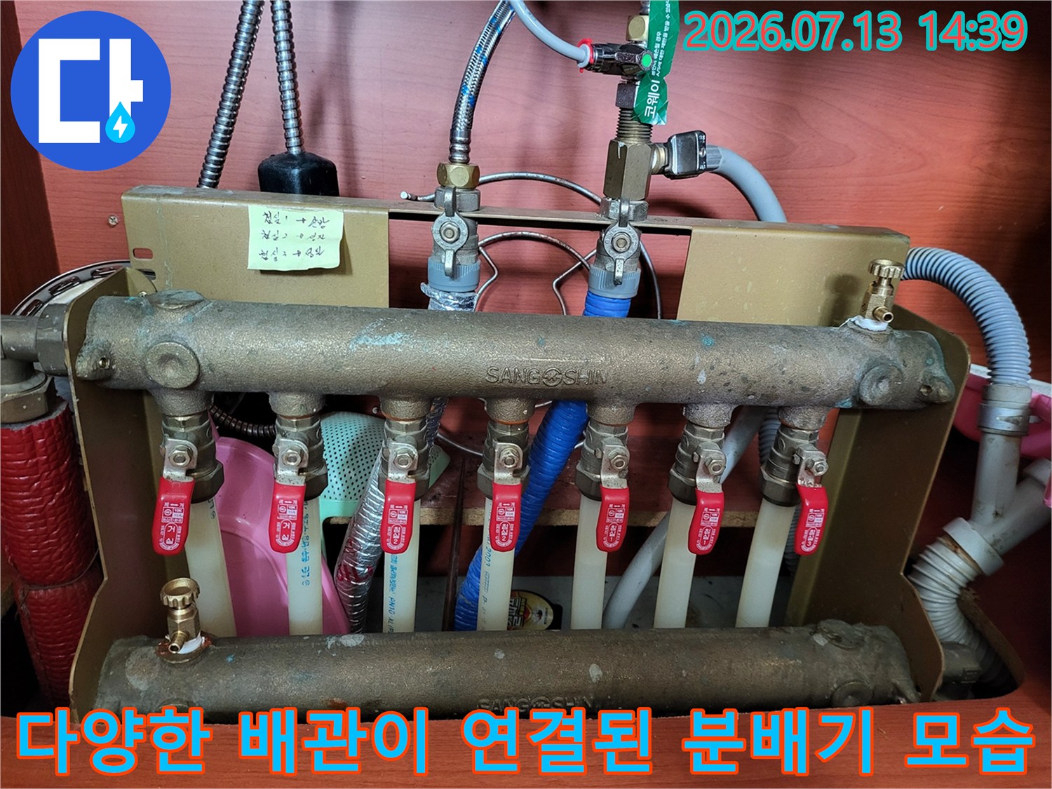 금속 관과 빨간색 제어 밸브가 설치된 보일러 분배기 사진
