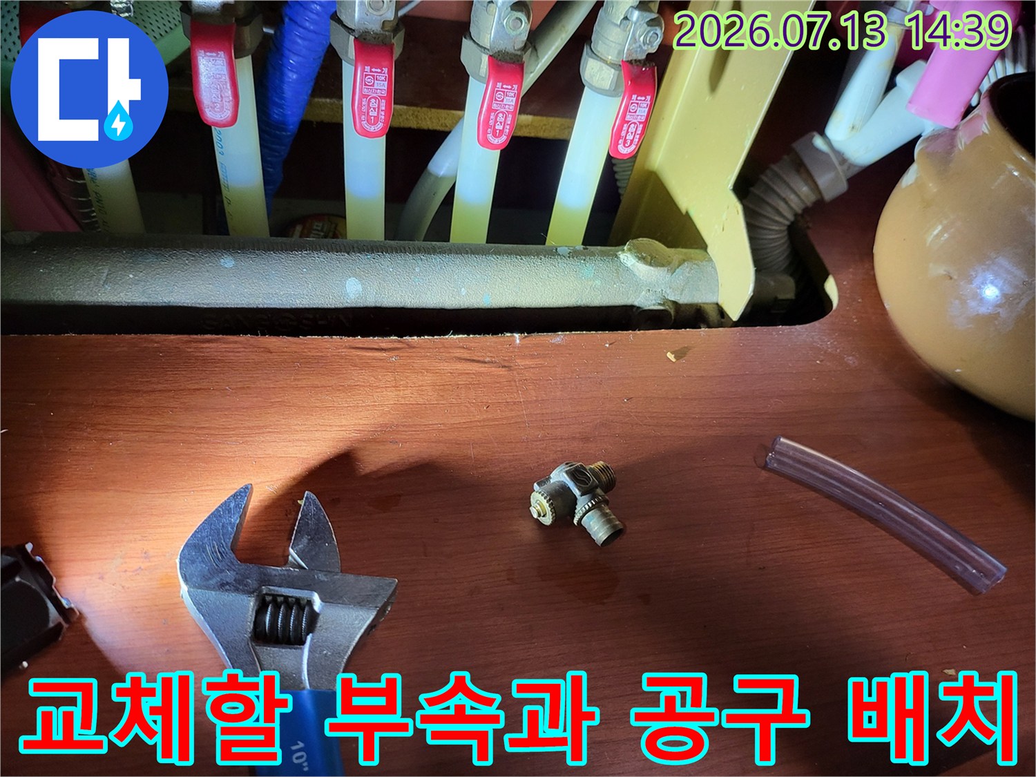 파란색-몽키스패너와-금속-T자-커넥터-그리고-투명한-호스가-놓인-상태